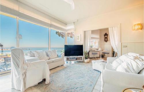 Una sala de estar con muebles blancos y vista al mar. en 3 Bedroom Cozy Home In Arenys De Mar, en Arenys de Mar