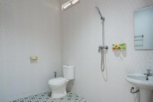 a bathroom with a shower and a toilet and a sink at Segara Hotel & Restaurant in Kintamani