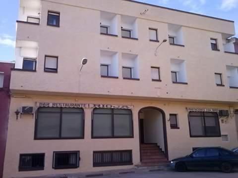 a building with a car parked in front of it at Pension Rioja in Quinto