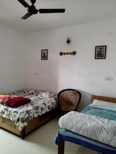 a bedroom with two beds and a ceiling fan at Corbett Green Orchard in Rāmnagar
