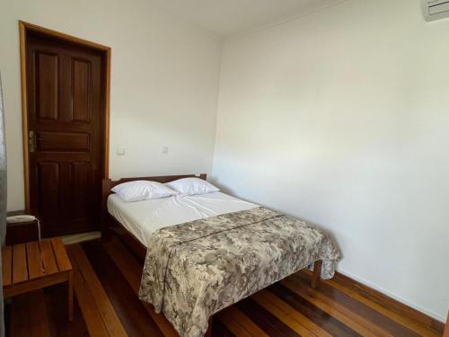 a small bedroom with a bed and a door at Residencial Aeroporto in São Tomé