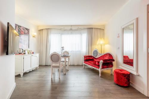 a living room with a red chair and a table at Hotel Beyond in Izmir