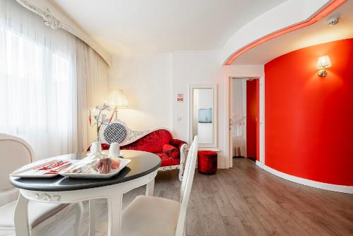 a living room with a table and a red wall at Hotel Beyond in Izmir