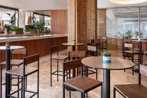 a restaurant with tables and chairs and a bar at Meliá South Beach in Magaluf