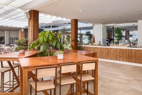 a restaurant with wooden tables and chairs and a bar at Meliá South Beach in Magaluf