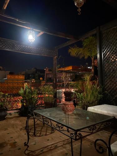 a patio with a table and potted plants at night at Riad Lahboul in Meknès