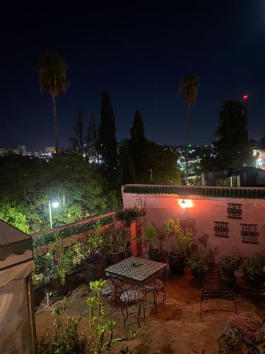 a patio at night with a table and chairs at Riad Lahboul in Meknès