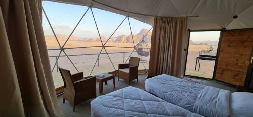 a bedroom with a bed and a large window at Daniela Camp Wadi Rum in Wadi Rum