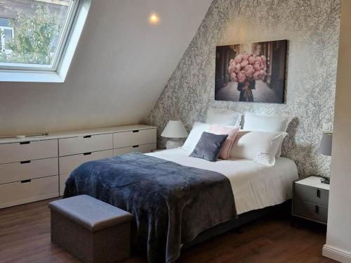 une chambre avec un grand lit avec un tableau au mur dans l'établissement Villa Jasmin Thionville, à Thionville