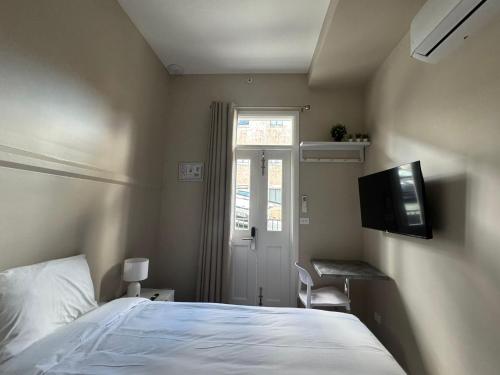 a bedroom with a bed and a television on the wall at K2 Brisbane in Brisbane