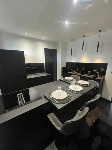 une cuisine avec une table et 4 assiettes. dans l'établissement Chambre 2624, à Limoges