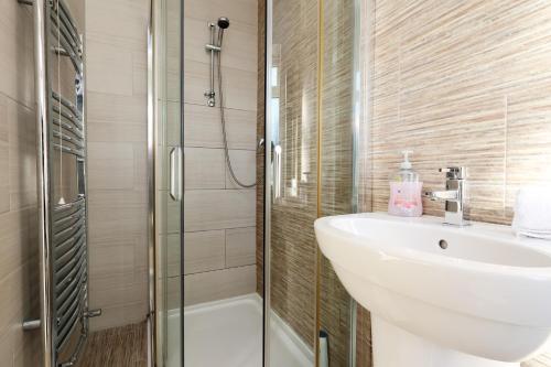 Un baño con lavabo, inodoro y ducha. en "Rosecroft" - Perfect Retreat for Business & Leisure - Close to Celtic Manor and ICC, en Newport