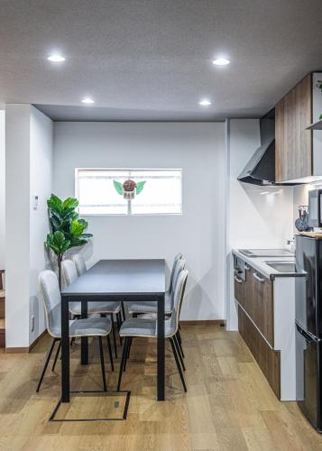 a dining room with a table and chairs in a kitchen at MIYU 繁花 near USJ in Osaka