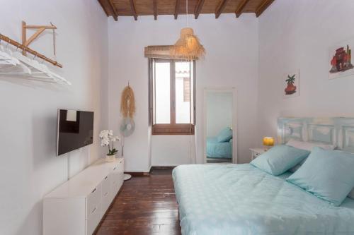 a bedroom with a blue bed and a television at Casa Libelvik en pleno centro Galdar con Terraza in Gáldar