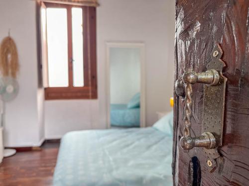 a door to a bedroom with a bed and a window at Casa Libelvik en pleno centro Galdar con Terraza in Gáldar