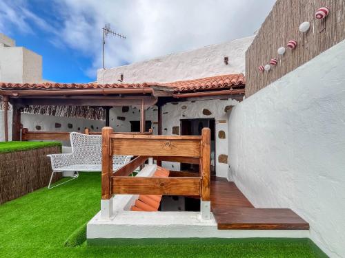 a wooden bench sitting on the side of a house at Casa Libelvik en pleno centro Galdar con Terraza in Gáldar