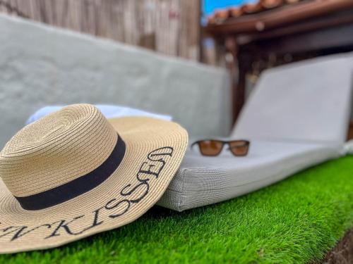 a straw hat and glasses sitting on top of a mattress at Casa Libelvik en pleno centro Galdar con Terraza in Gáldar