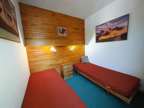 - une chambre avec un lit rouge et un mur en bois dans l'établissement Résidence Lauzes G - LAUZES 55 MAE-6201, à Valmorel