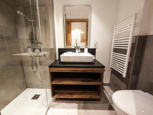 une salle de bain avec un lavabo, une douche et des toilettes dans l'établissement Les Chalets Du Cheval Noir - Construction neuve proche de toutes les commodités MAE-6441, à Saint-Martin-de-Belleville