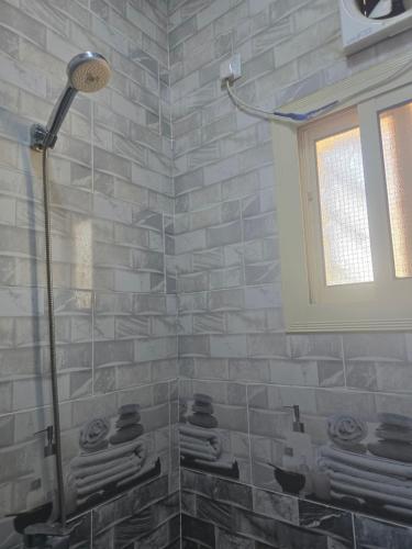 a bathroom with a shower with a stone wall at شقق عبدالله in AlUla