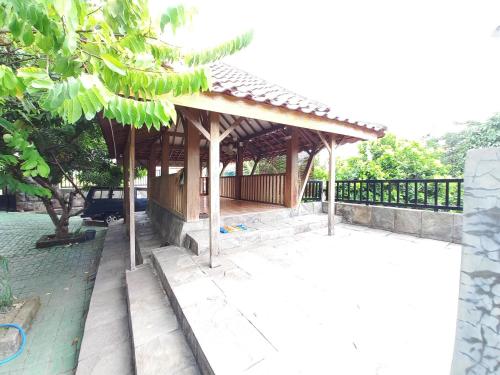 a building with a pavilion in a park at Alif House Syariah Redpartner near Taman Dayu Pandaan in Pasuruan