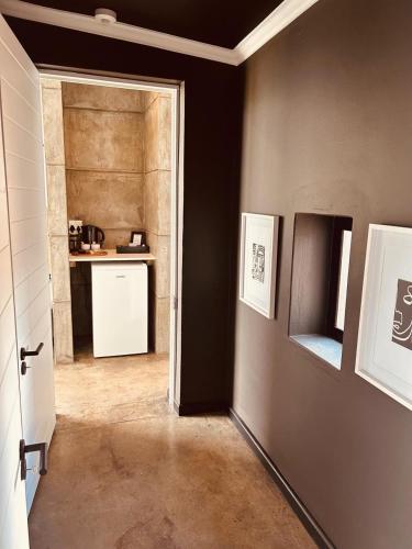 a room with a hallway with a kitchen and a door at Cellar Pods Blue in Robertson