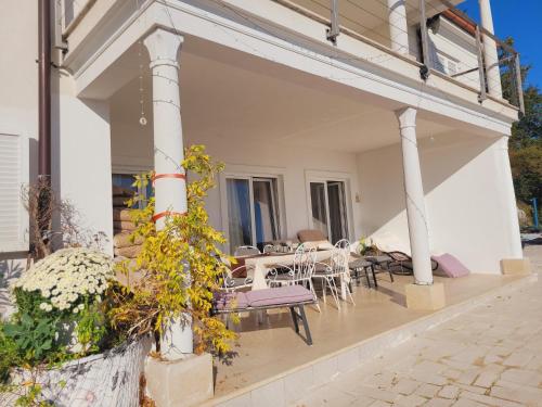 a house with a patio with a table and chairs at Apartments Chiara mit Meerblick und Pool und Jacuzzi in Lovran