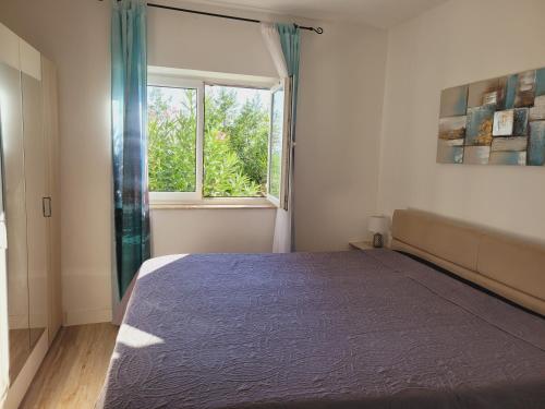 a bedroom with a large bed and a window at Apartments Chiara mit Meerblick und Pool und Jacuzzi in Lovran