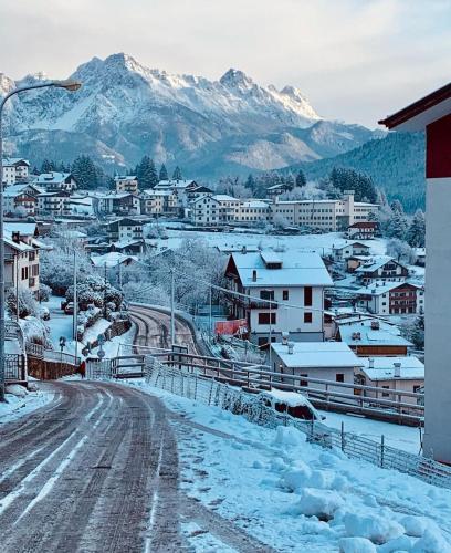 a snow covered city with mountains in the background at RomAnna in Domegge di Cadore
