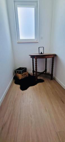 une pièce vide avec une table et une fenêtre dans l'établissement Gite Alsacien, à Roggenhouse