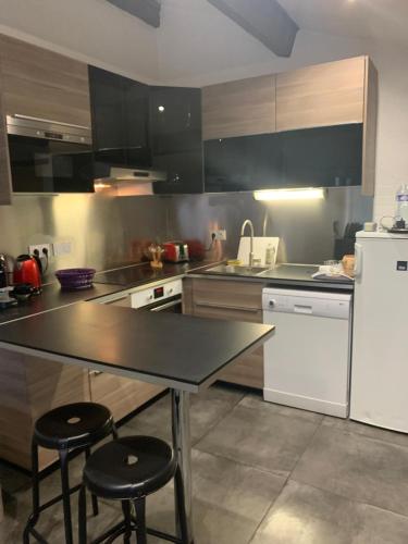 - une cuisine avec une table et deux tabourets dans l'établissement Maisonnette très cosy au calme, à Aubagne