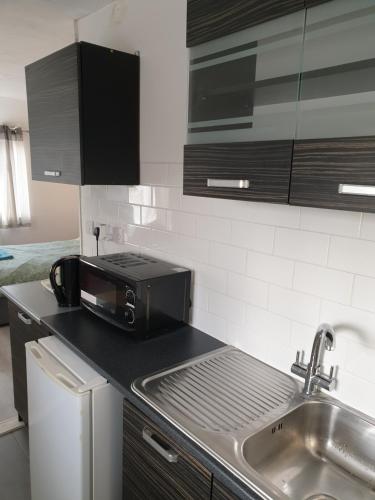 a kitchen with a sink and a microwave at Studios in Ely