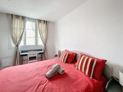 - une chambre avec un lit rouge et des oreillers rouges et blancs dans l'établissement Le Emmanuel - Place du change, à Compiègne