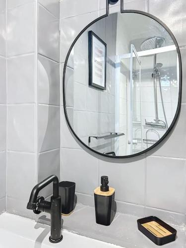 une salle de bain avec un lavabo et un miroir dans l'établissement Le Emmanuel - Place du change, à Compiègne