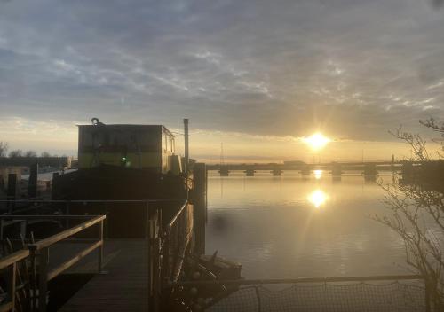 a boat parked in a marina with the sunset in the background at The Island Houseboat in Amsterdam