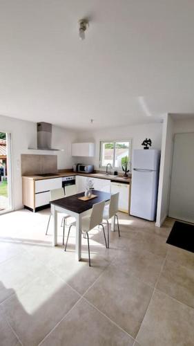 une cuisine avec une table et des chaises dans une pièce dans l'établissement Maison Castres Gironde proche Bordeaux, à Castres-Gironde