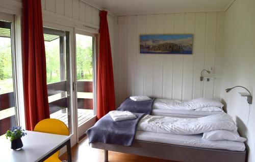 a room with two beds in front of a window at Raulandsakademiet in Rauland