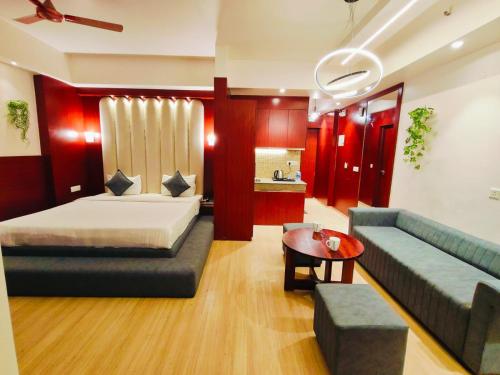 a living room with a bed and a couch and a table at The Grace Residency - Gomtinagar, Lucknow in Lucknow