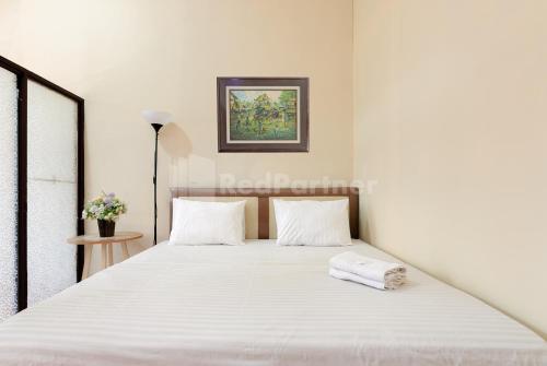 a bedroom with a large white bed with white pillows at SR Residence near Mall Ciputra Cibubur Mitra RedDoorz in Bekasi