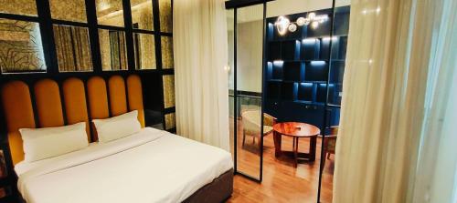 a bedroom with a large bed and a table at The Grace Residency - Gomtinagar, Lucknow in Lucknow