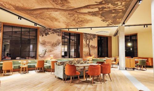 a lobby with a table and chairs and a mural at Kyriad Prestige Compiègne Hotel & Spa in Compiègne