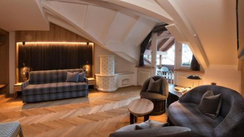 a living room with couches chairs and a table at Hotel Genziana in Ortisei