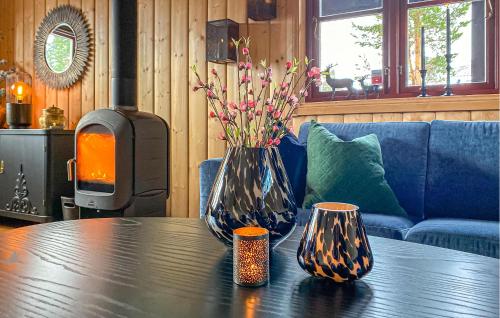 a table with two vases on it with a fireplace at 4 Bedroom Gorgeous Home In Bjorli in Bjorli