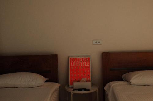 a bedroom with two beds and a sign on the wall at Bao Dao Da Lou in Suao