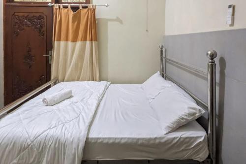 a bedroom with a bed with white sheets at Redisa RedPartner near RS Saiful Anwar in Malang