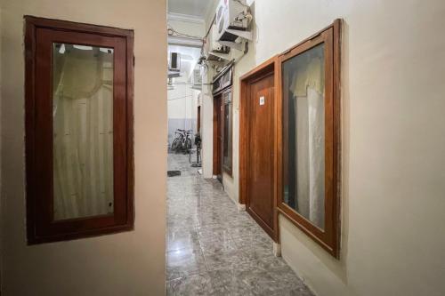 a hallway with wooden doors and tiled floors in a building at Redisa RedPartner near RS Saiful Anwar in Malang