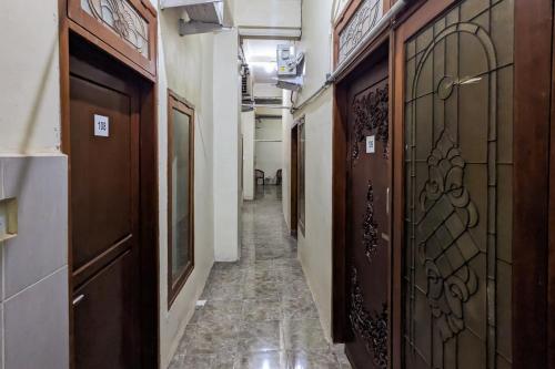 a corridor with wooden doors and tile floors at Redisa RedPartner near RS Saiful Anwar in Malang
