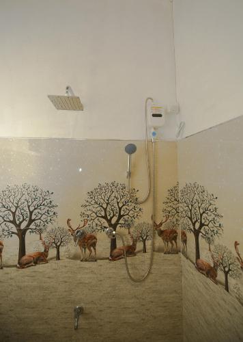 a bathroom with a mural of trees and giraffes at Lake Side Resort in Kekirawa