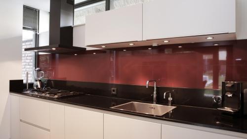 a kitchen with white cabinets and a sink at Dutchen Villapark Mooi Schoorl in Schoorl