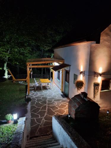 a house with a patio at night with lights at Vikendica WoodNook Kosmaj - Šumski kutak in Sopot